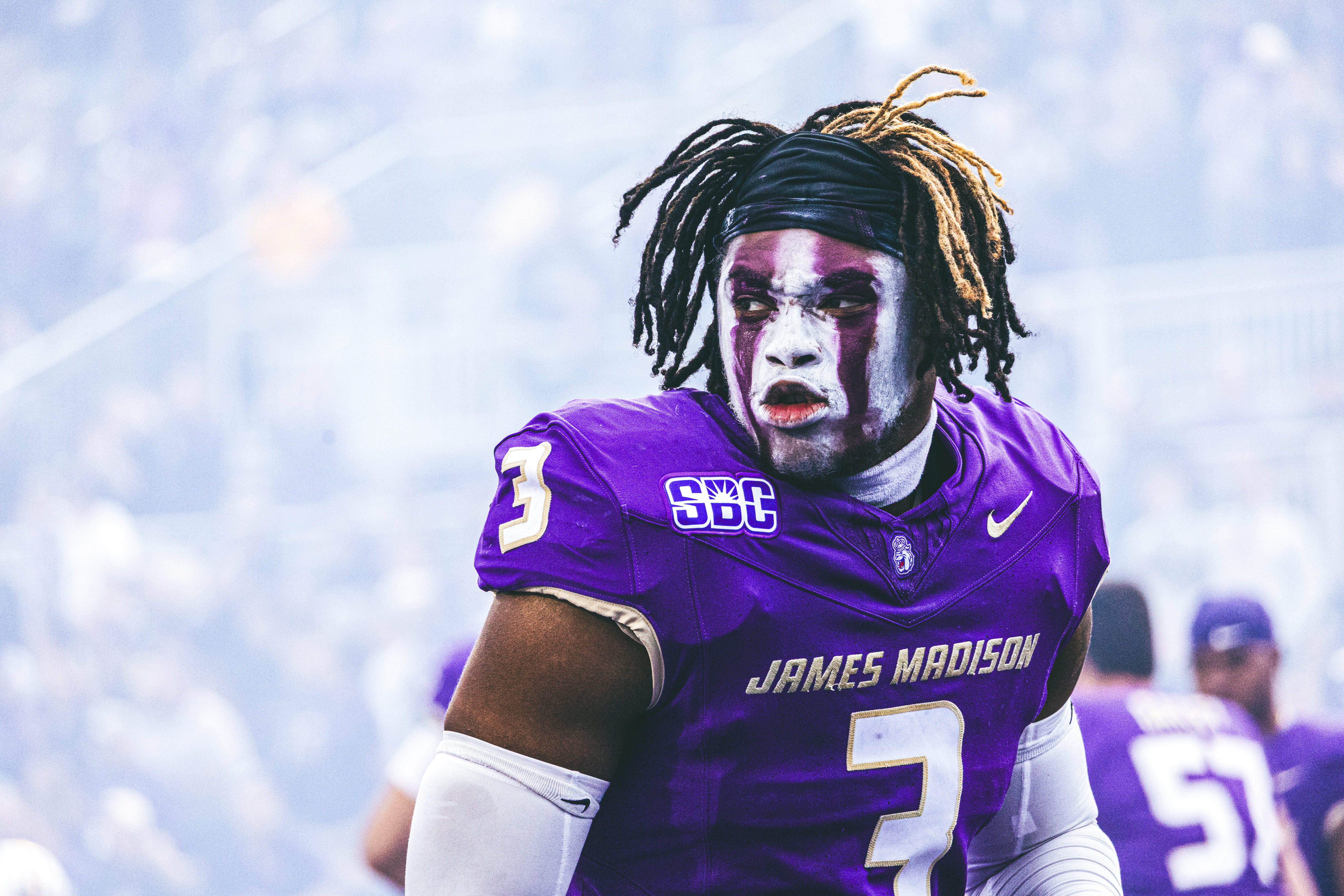Close-up portrait of a JMU football player in a purple jersey